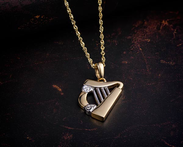 gold harp necklace styled on a dark background
