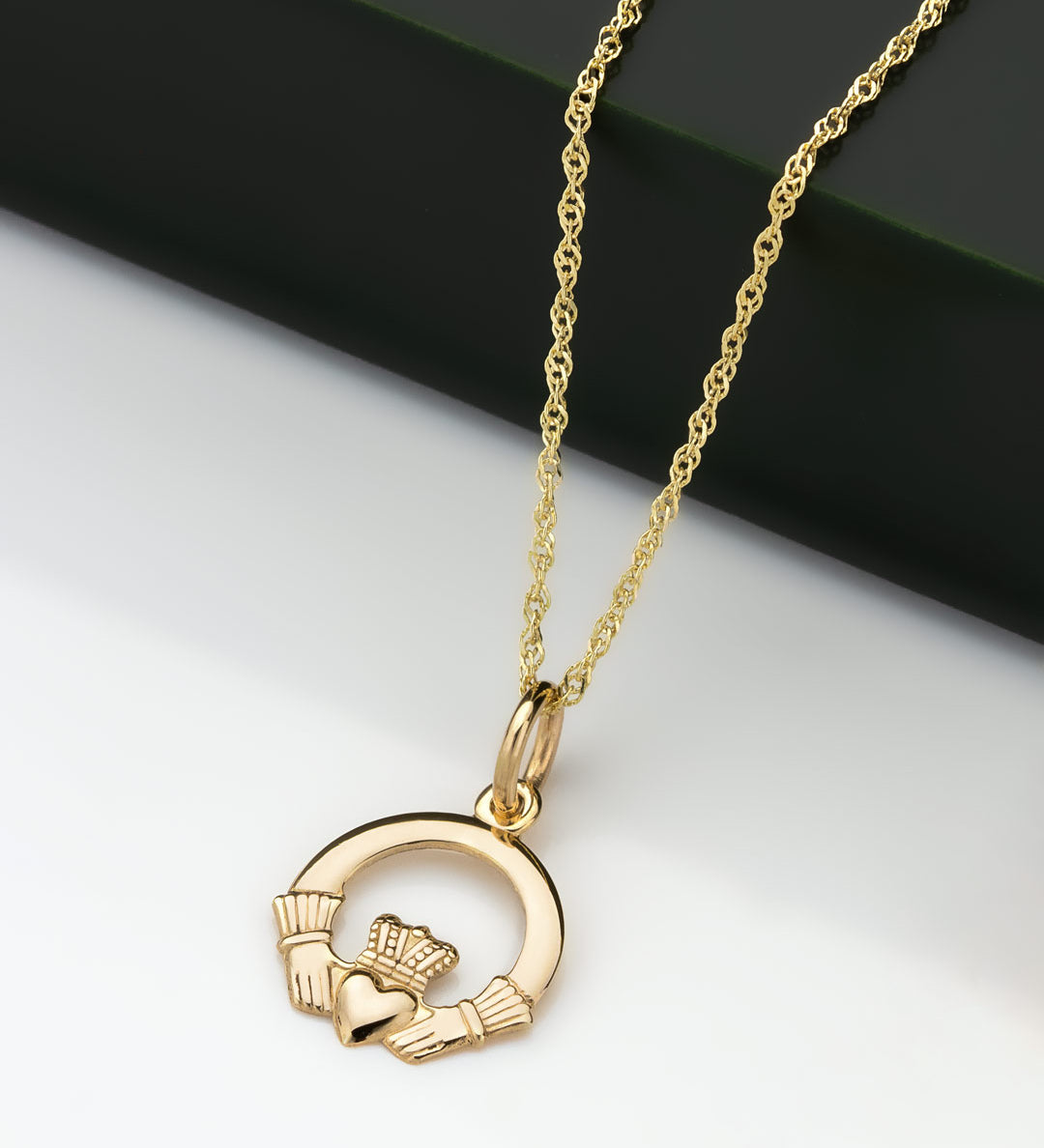 lifestyle image of small gold Claddagh pendant
