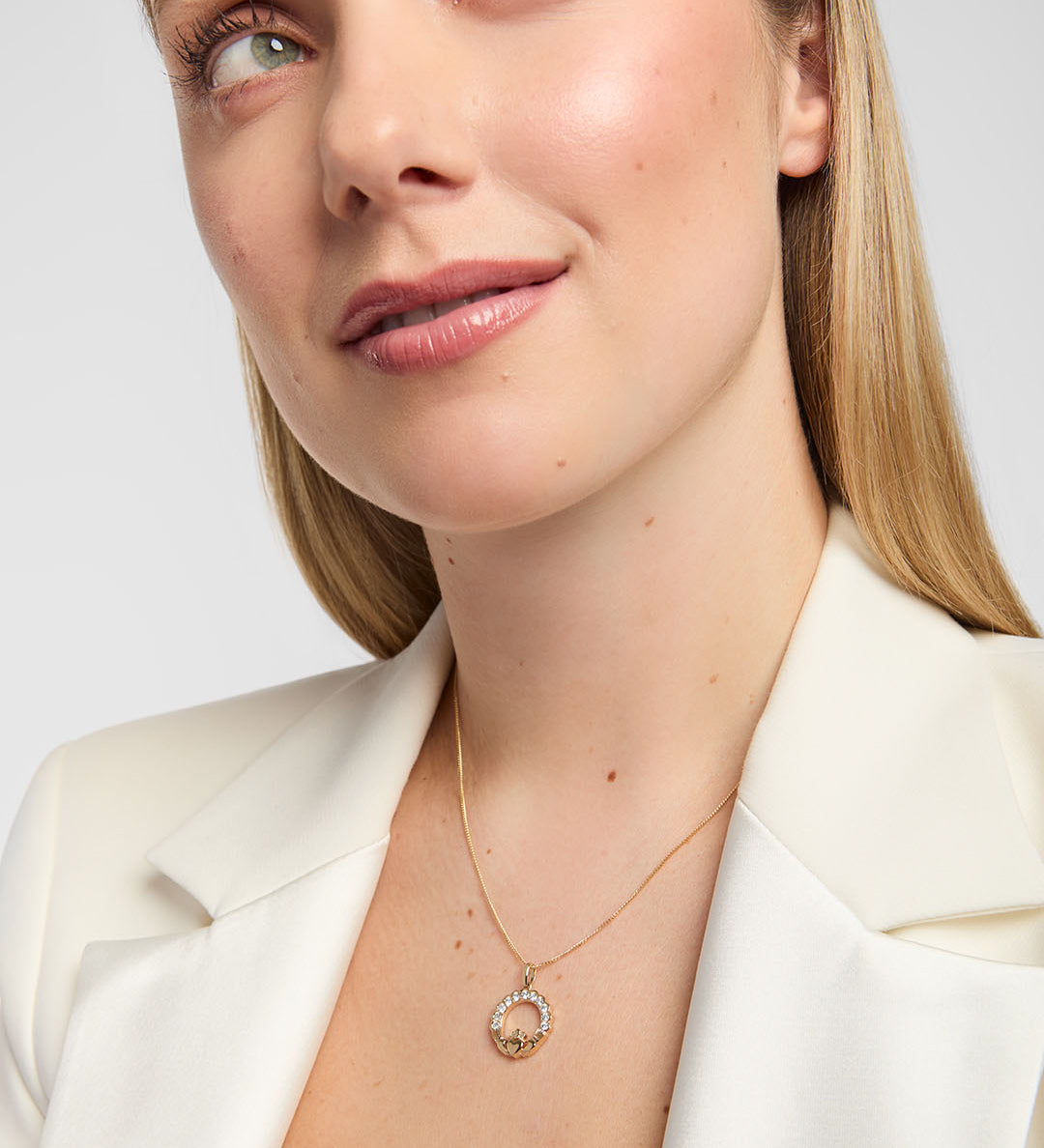 Female model wearing an elegant 14K gold Claddagh necklace accented with brilliant diamonds