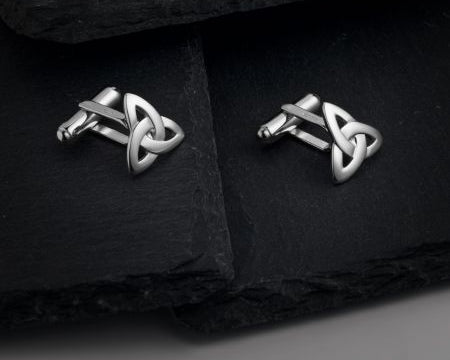 styled image of silver celtic cufflinks on dark grey background