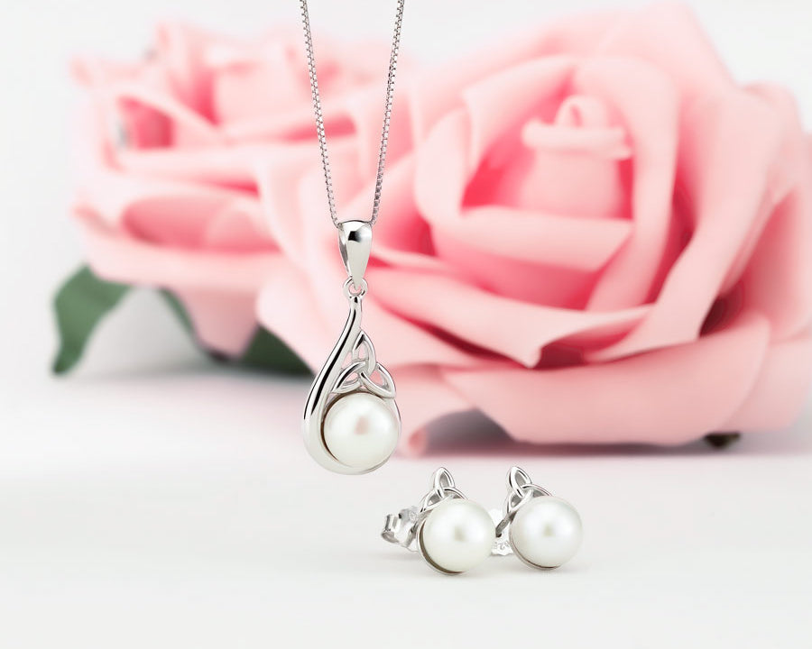 a set of pearl Trinity Knot necklace and earrings on the styled background