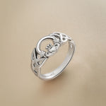 close-up image of Solvar Celtic Claddagh ring in silver on a beige background