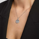 Silver Celtic spiral pendant necklace from Solvar on a person wearing a black blazer.