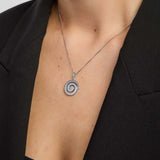 Silver Celtic spiral pendant necklace from Solvar on a person wearing a black blazer.