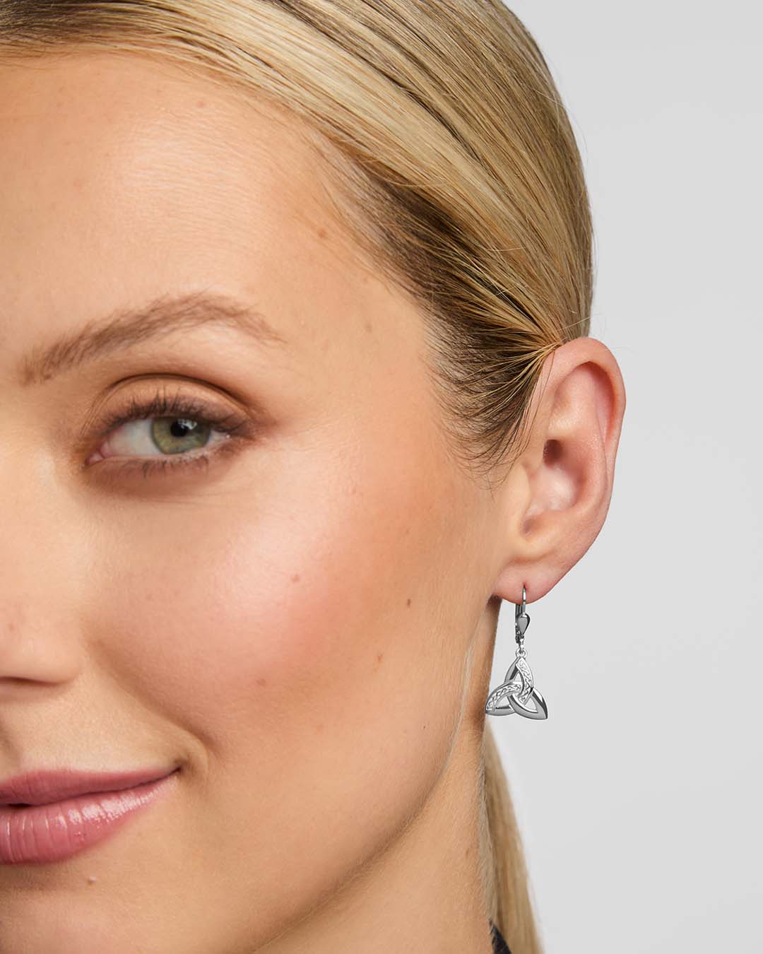 close-up image of a female model wearing Celtic Trinity Knot earrings in silver