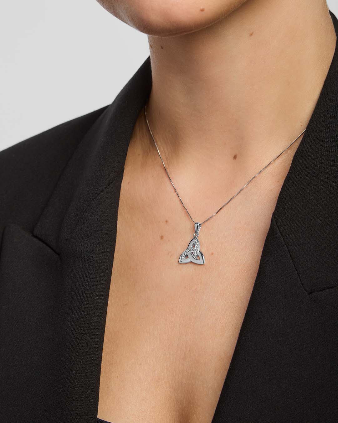 close-up image of celtic trinity knot pendant on a model