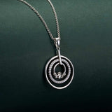 lifestyle image of claddagh celtic circle necklace on green background