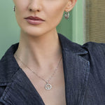 sterling silver claddagh hoop earrings and claddagh necklace on a model