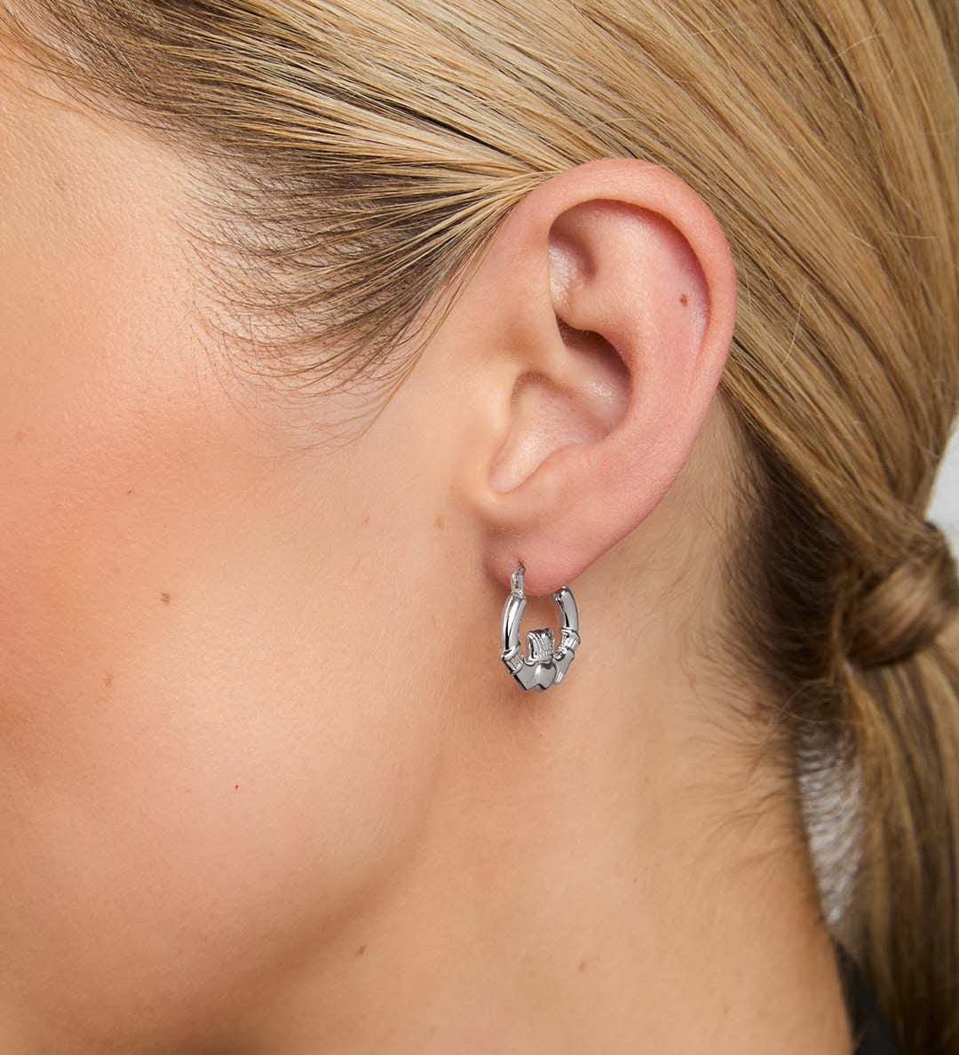close-up image of claddagh  hoop earrings on a female model