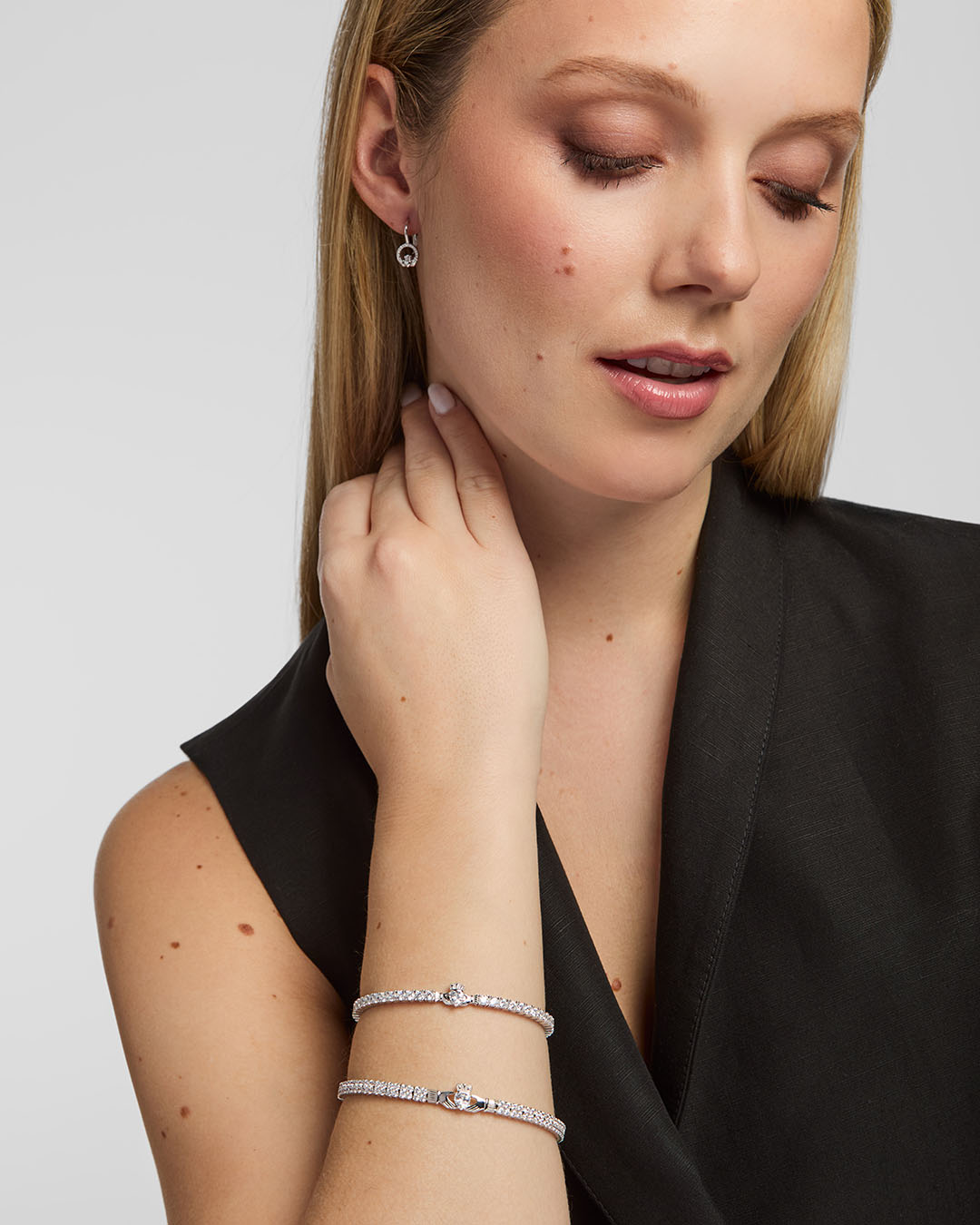 Lifestyle image of Solvar Claddagh tennis bracelet and bangle worn on a woman’s wrist in a relaxed setting
