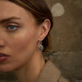 lifestyle image of a model wearing marble and marcasite shamrock earrings