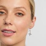 green marble saint brigids cross drop earrings on a model