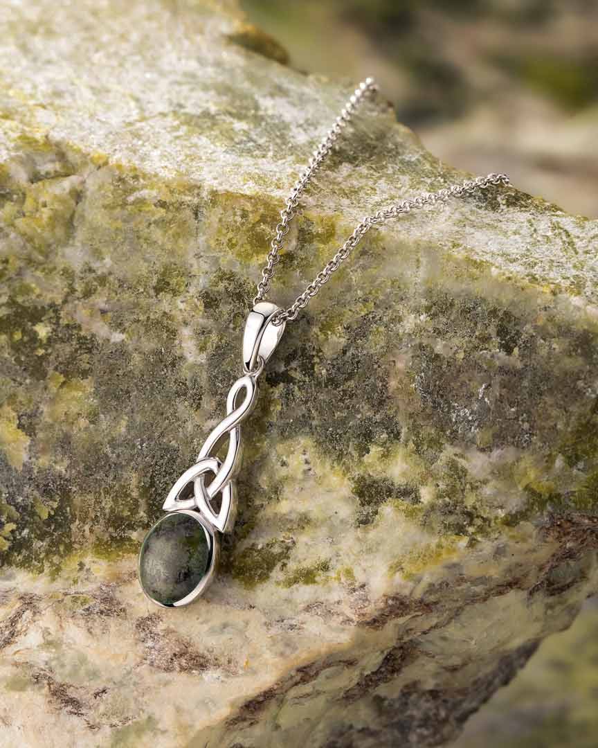 lifestyle image of connemara marble trinity knot pendant on green marble background
