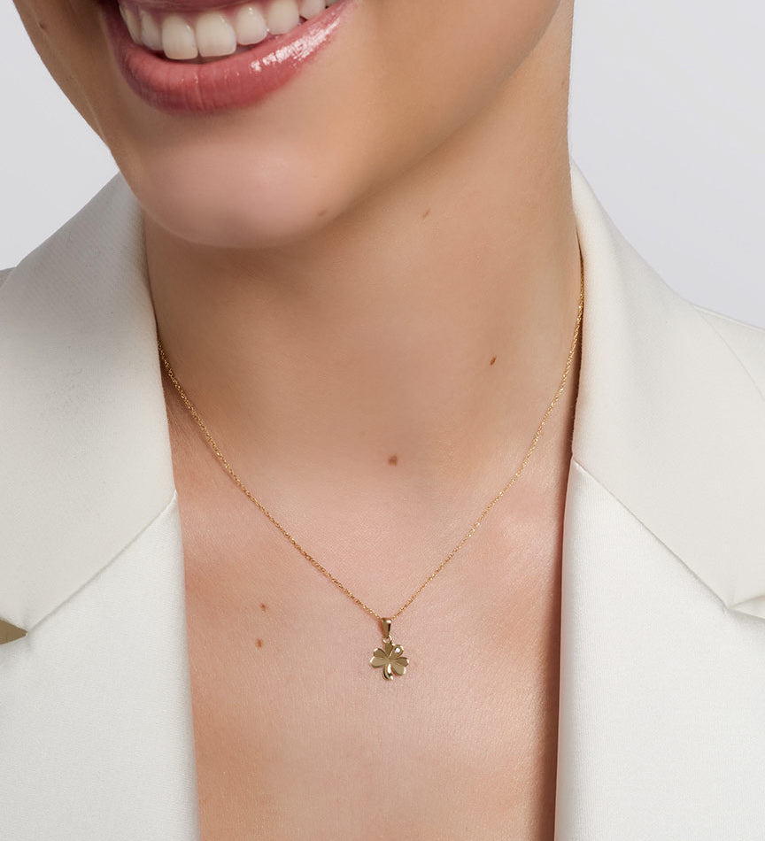 yellow gold cz shamrock necklace presented on a model