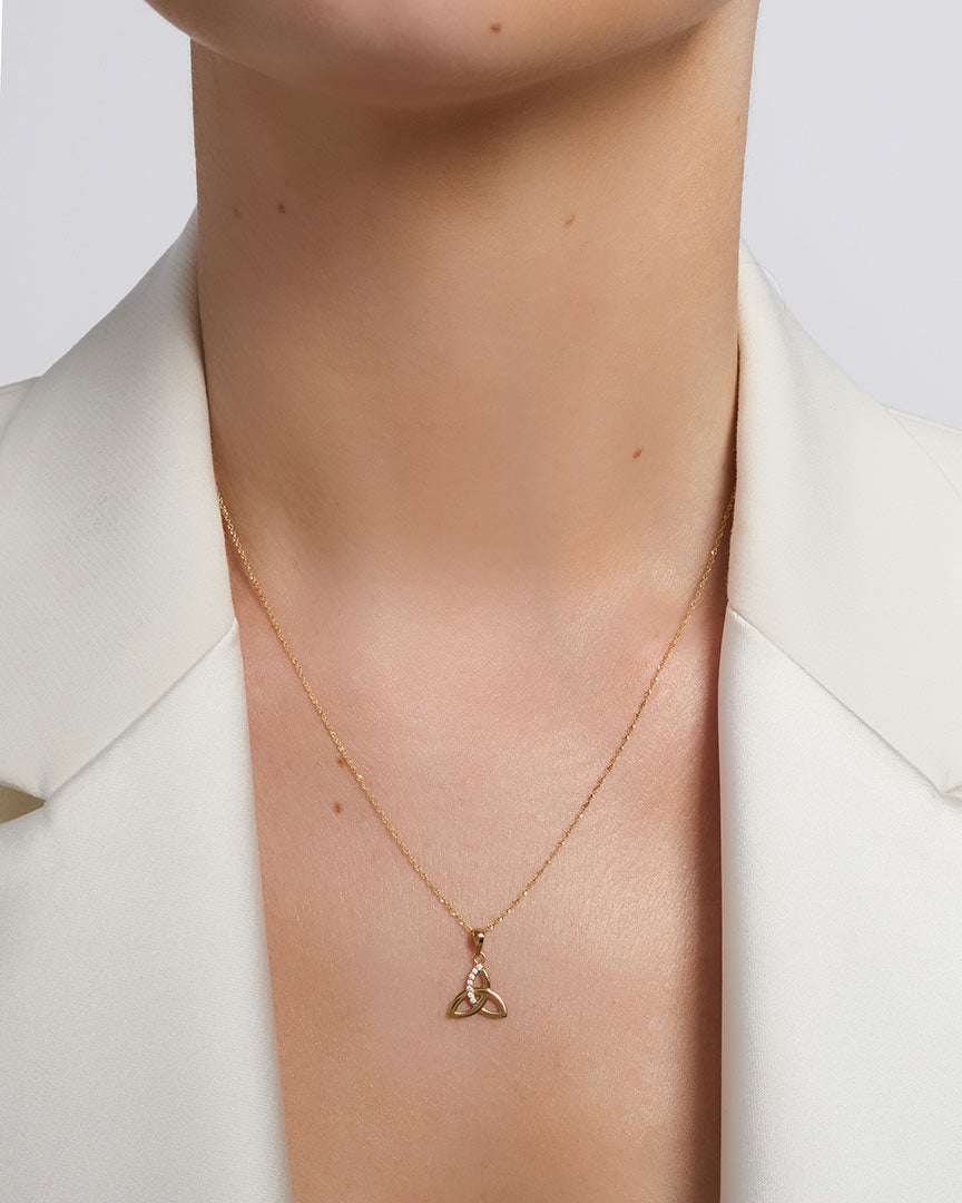 yellow gold cz trinity knot necklace presented on a model