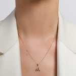 yellow gold cz trinity knot necklace presented on a model