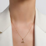 yellow gold cz trinity knot necklace presented on a model