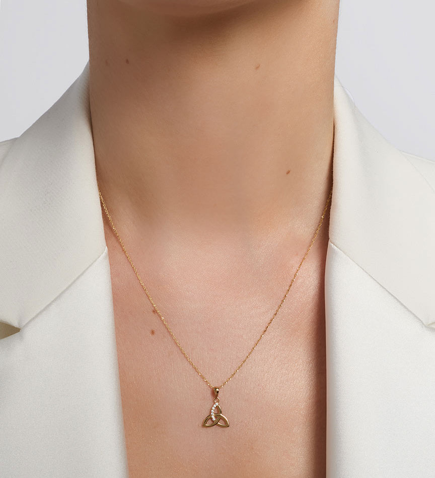 yellow gold cz trinity knot necklace presented on a model