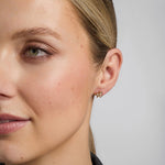 close-up image of a model wearing gold diamond shamrock earrings s33482 