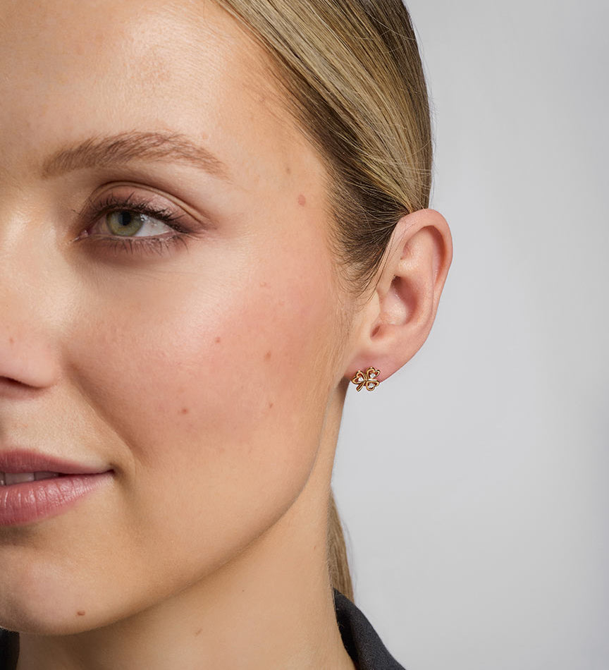close-up image of a model wearing gold diamond shamrock earrings s33482 