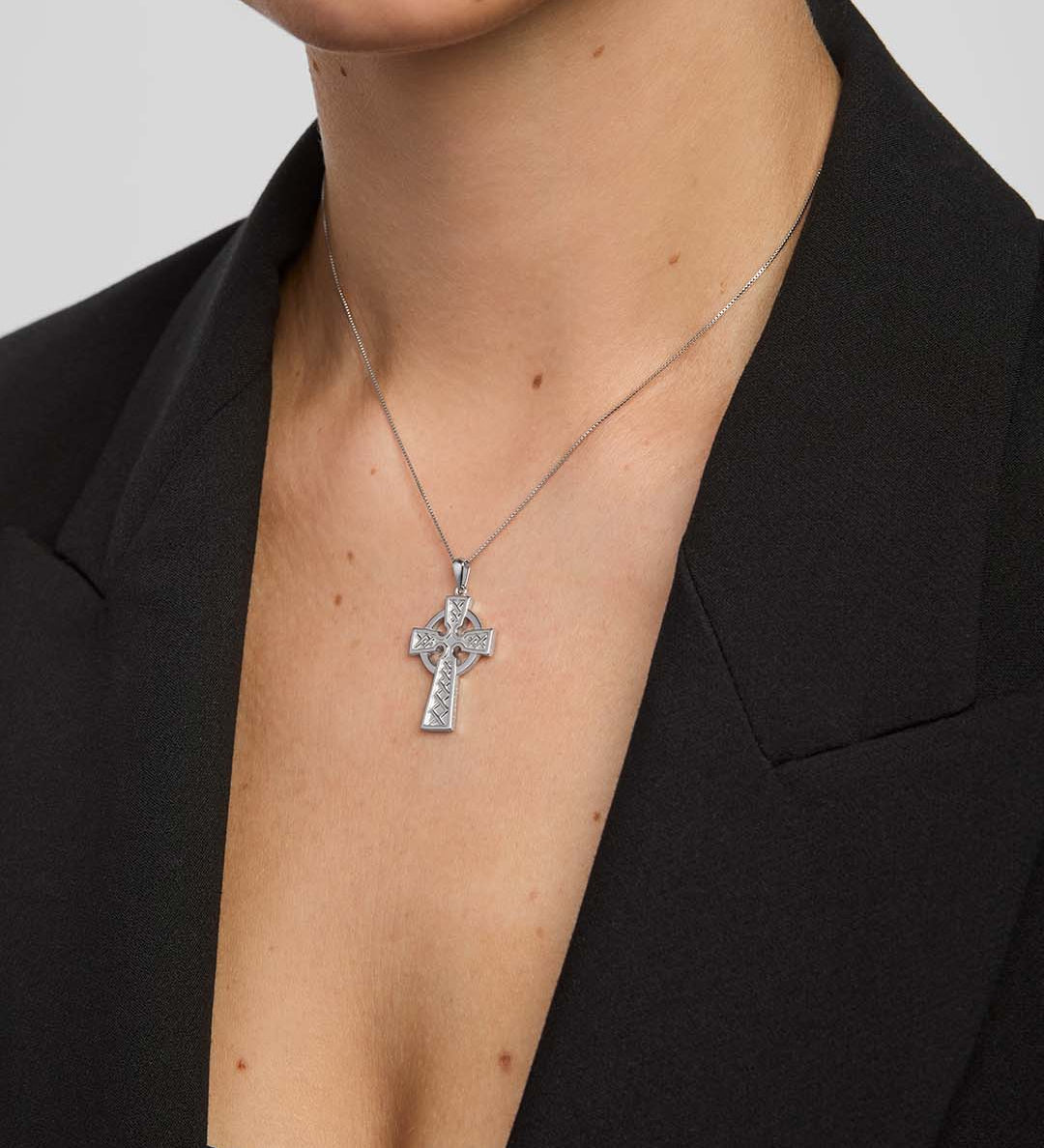 close-up image of double-sided embossed celtic cross pendant on a model