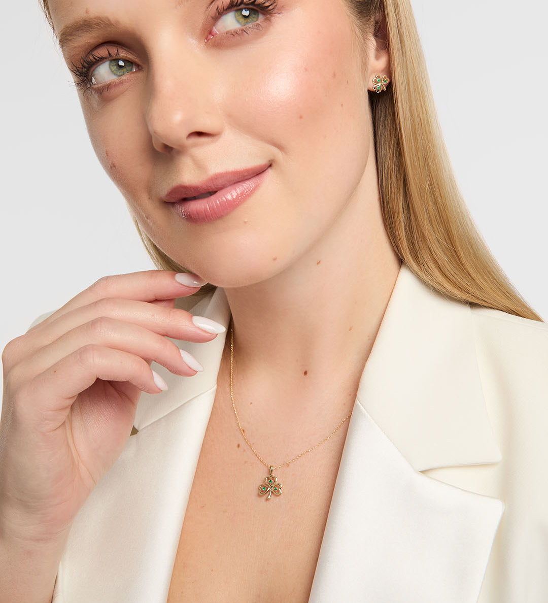 Close-up of a person in a white blazer wearing a Solvar gold Trinity knot bracelet with diamond links