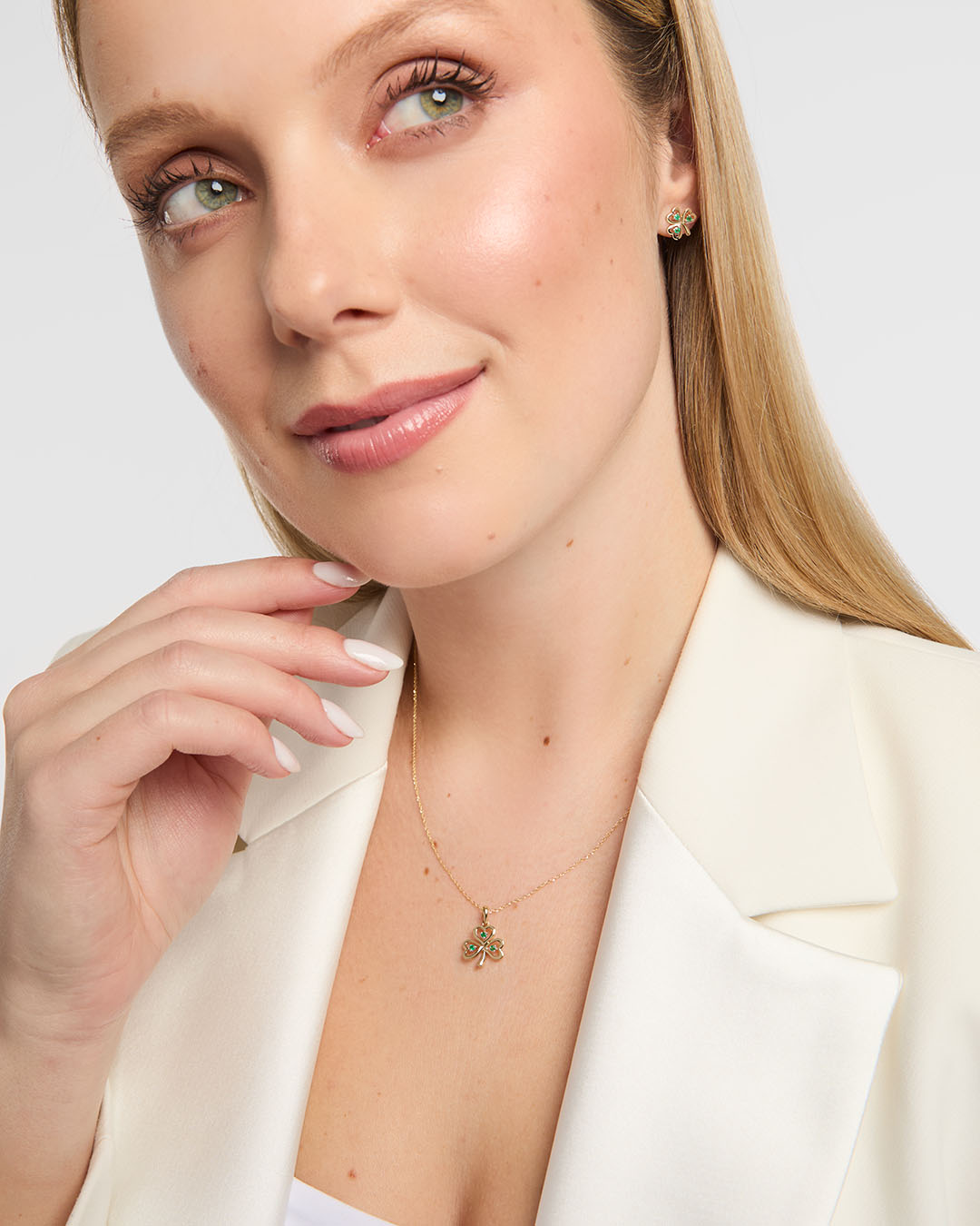 Close-up of a person in a white blazer wearing a Solvar gold Trinity knot bracelet with diamond links