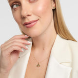 Close-up of a person in a white blazer wearing a Solvar gold Trinity knot bracelet with diamond links