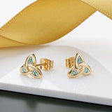 lifestyle image of emerald set gold trinity knot earrings