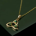 lifestyle image of emerald celtic necklace on green background
