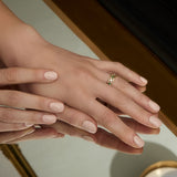 a model wearing yellow gold emerald and cz Trinity Knot band ring from Solvar