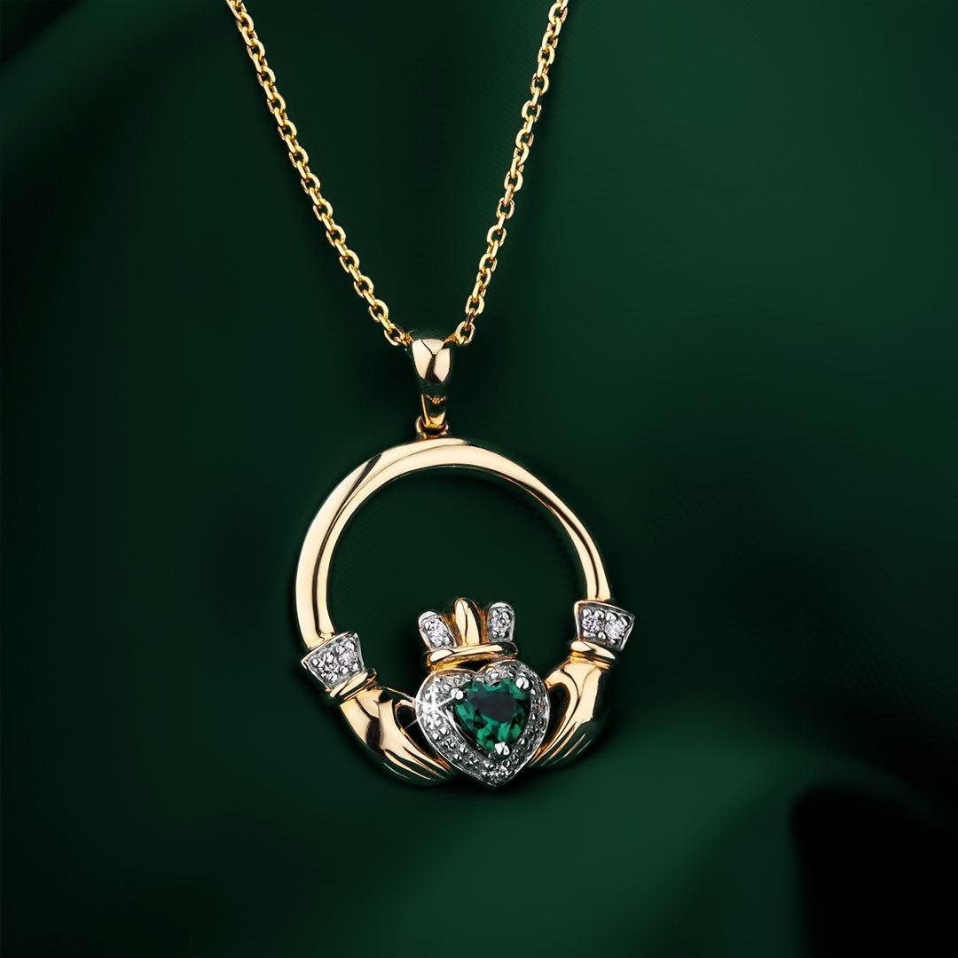 lifestyle image of emerald gold Claddagh pendant on green background