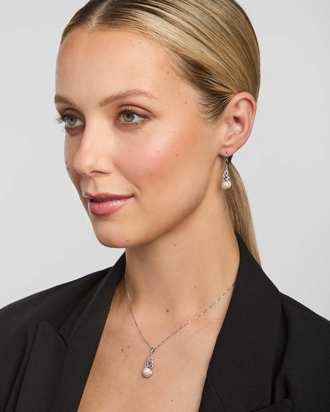 a set of freshwater pearl celtic necklace and earrings presented on a model