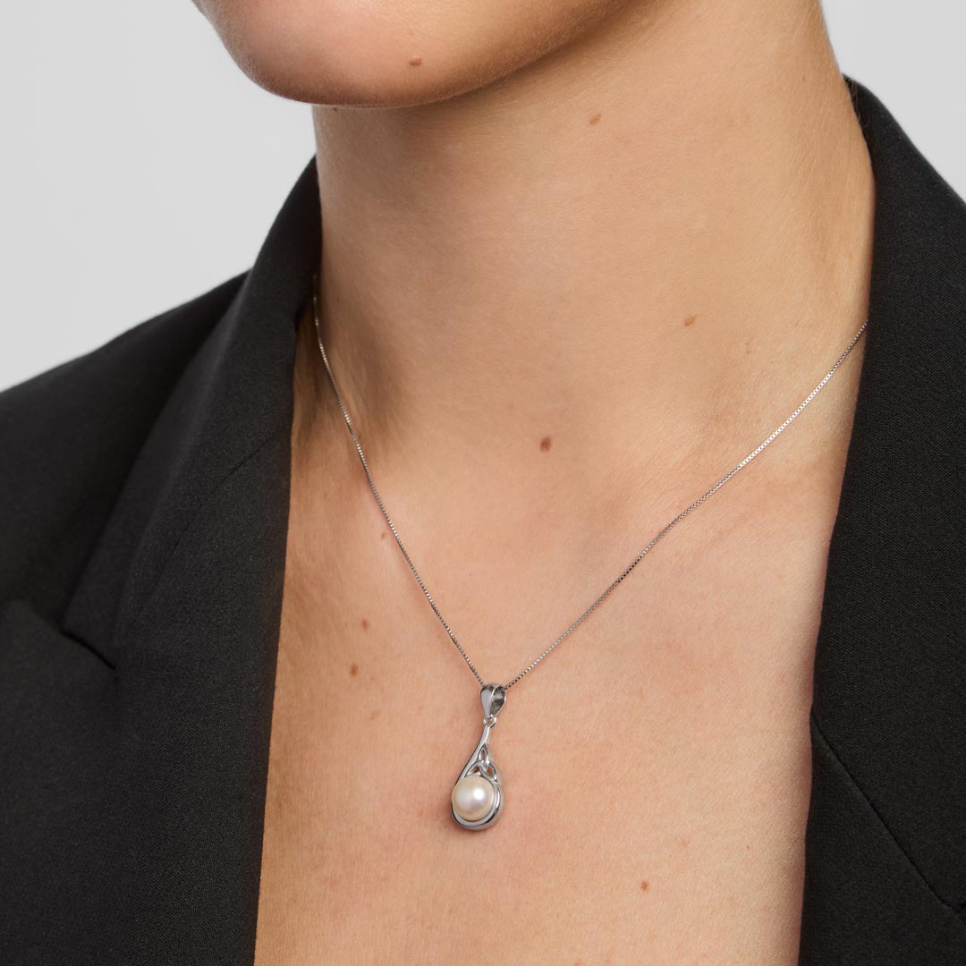 close-up image of a woman wearing freshwater pearl trinity knot necklace in silver