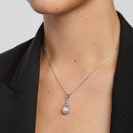 close-up image of a woman wearing freshwater pearl trinity knot necklace in silver