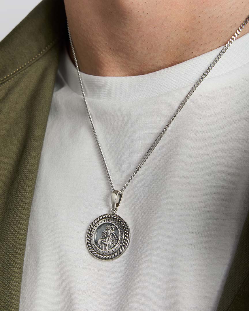 closeup image of silver st Christopher medal pendant on a male model