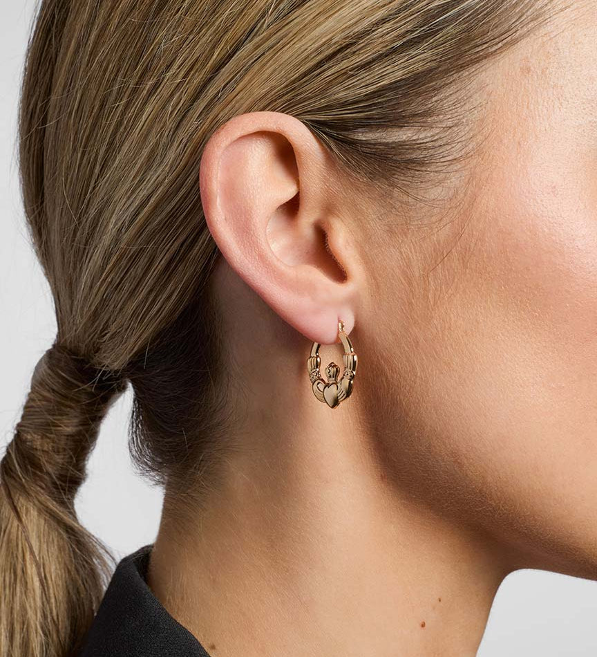 model wearing yellow gold Claddagh hoop earrings from Solvar