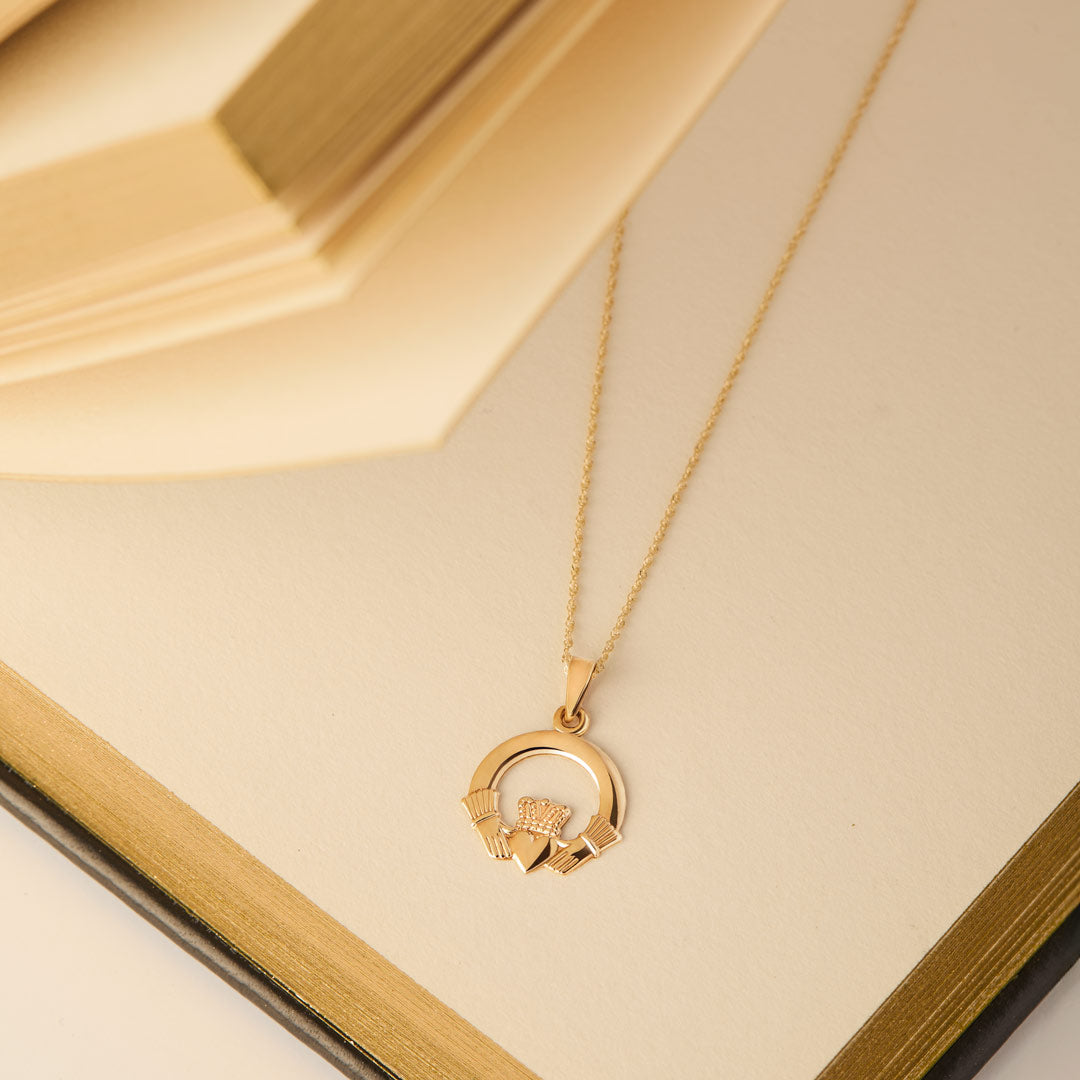 lifestyle image of gold Claddagh necklace placed in the open notebook the from Solvar