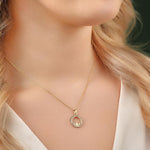 yellow gold cs round claddagh necklace on a model