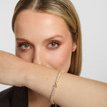 close-up image of gold plated trinity knot  celtic tennis bracelet on a woman's wrist