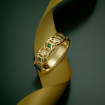 lifestyle image of gold diamond and emerald trinity knot ring band
