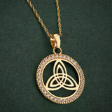 lifestyle image of yellow gold trinity knot round necklace on green background