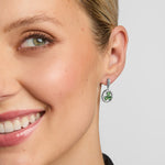 close-up image of a woman wearing green stone shamrock earrings