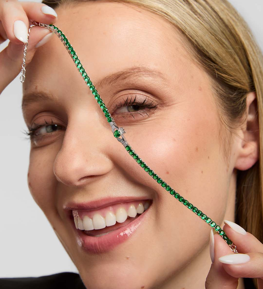 lifestyle image of green cz tennis bracelet with the Claddagh centre from Solvar