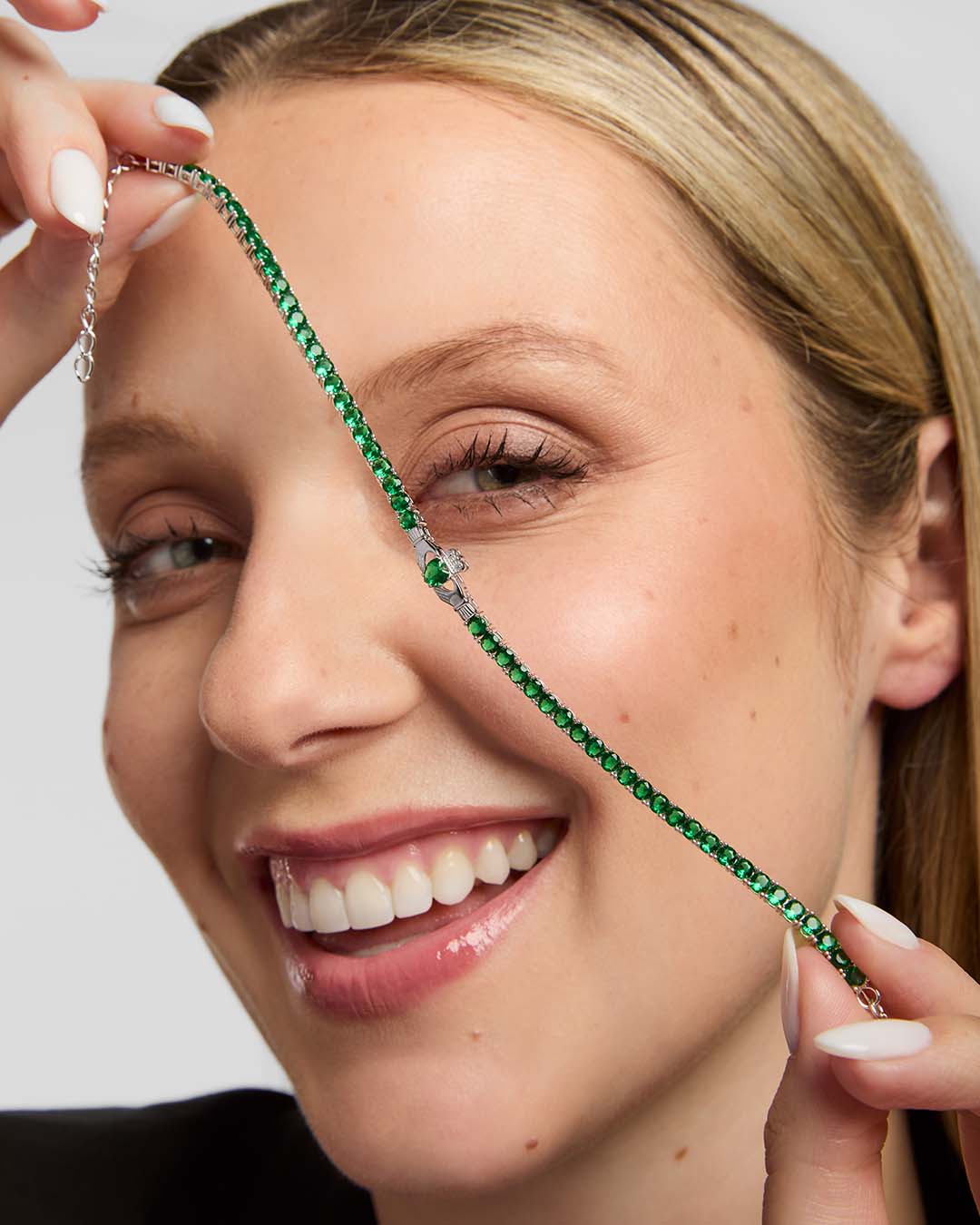 lifestyle image of green cz tennis bracelet with the Claddagh centre from Solvar