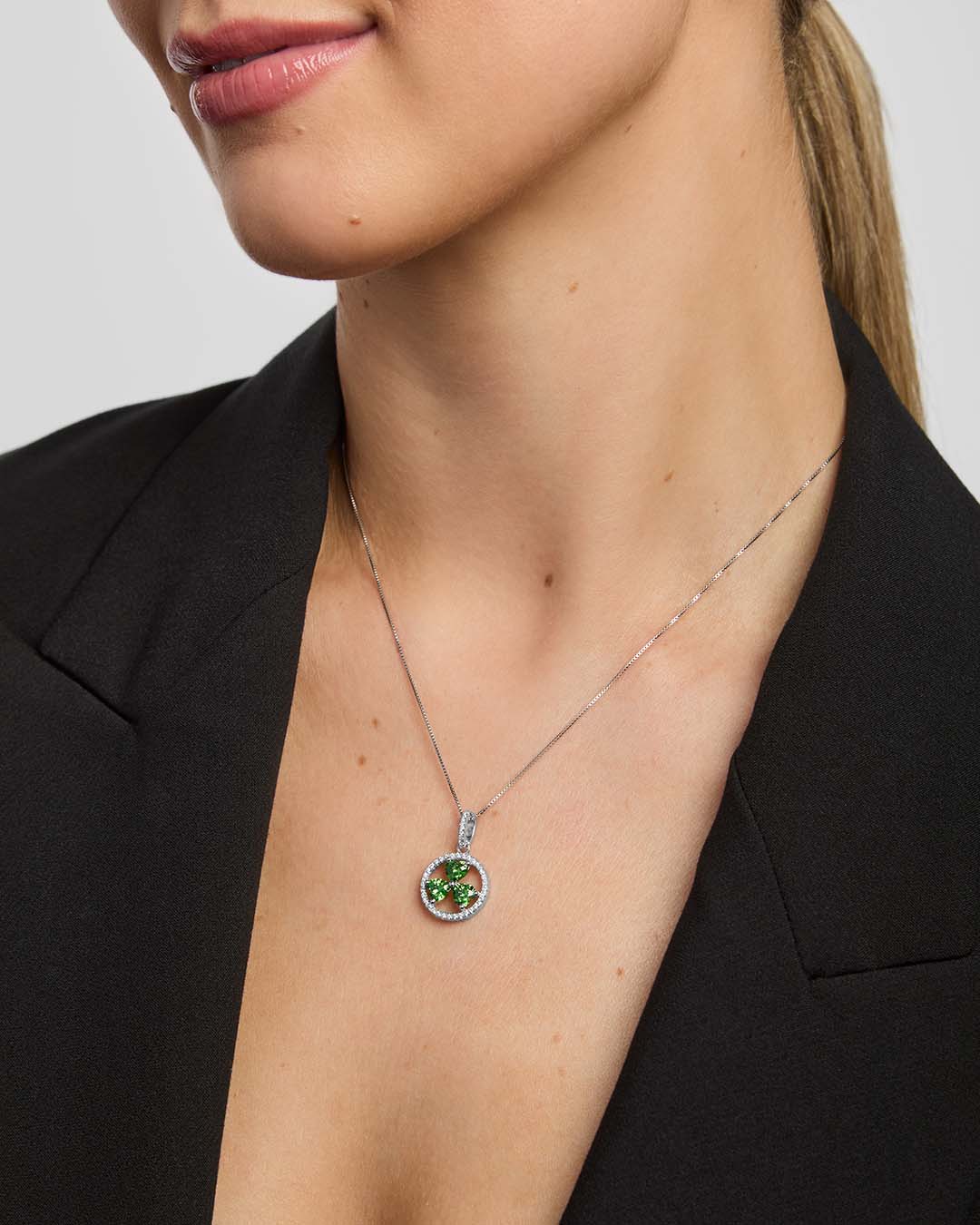 a female model wearing a green crystal Shamrock necklace