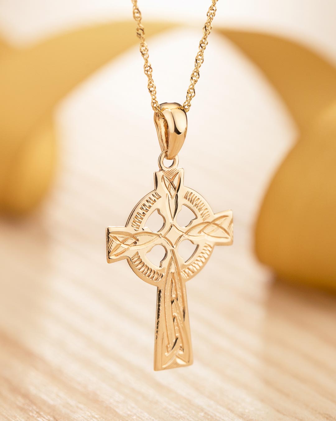 lifestyle image of hand engraved gold celtic cross necklace 1