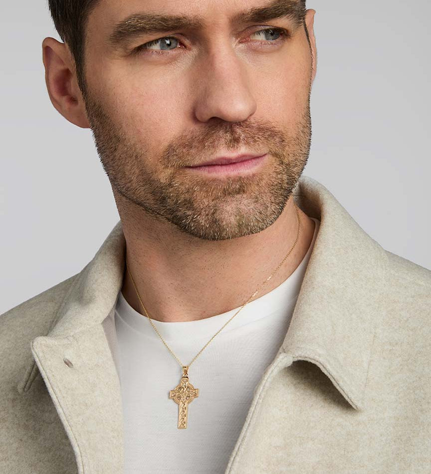 a male model wearing large yellow gold celtic cross pendant