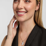 a close-up portrait of a female wearing a dark top and a thin chain necklace. The necklace features a large pendant shaped like the island of Ireland, positioned at the centre of the chest.