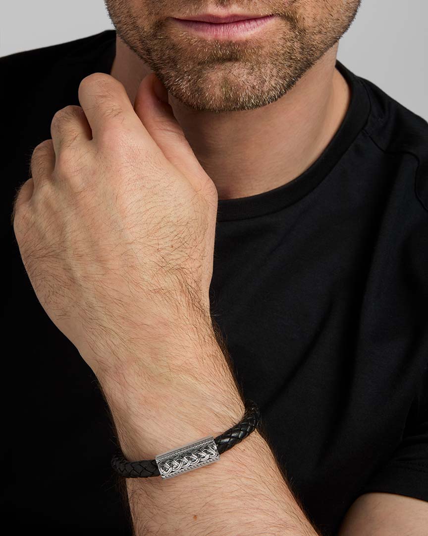 closeup image of black leather silver Celtic bracelet on a male model